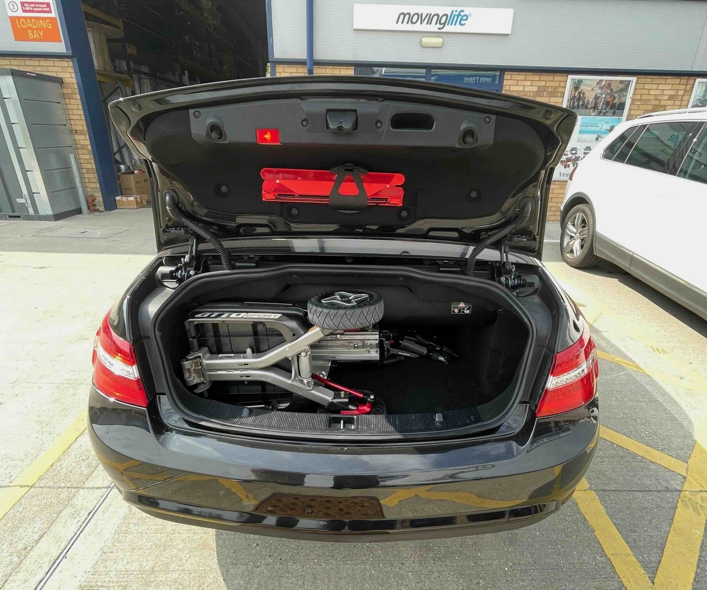 ATTO folding mobility scooter in the boot of a Mercedes-Benz E-Class Cabriolet convertible
