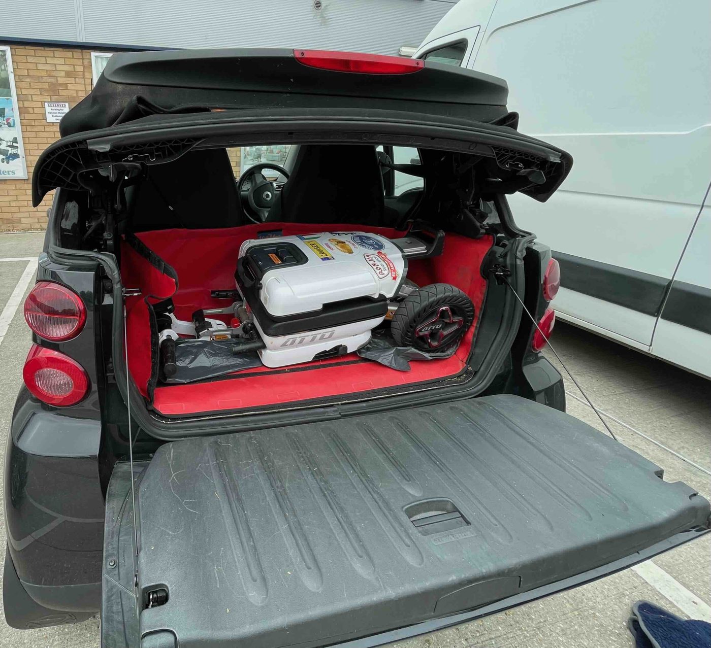 ATTO folding mobility scooter in the back of a Smart Fortwo Cabrio convertible