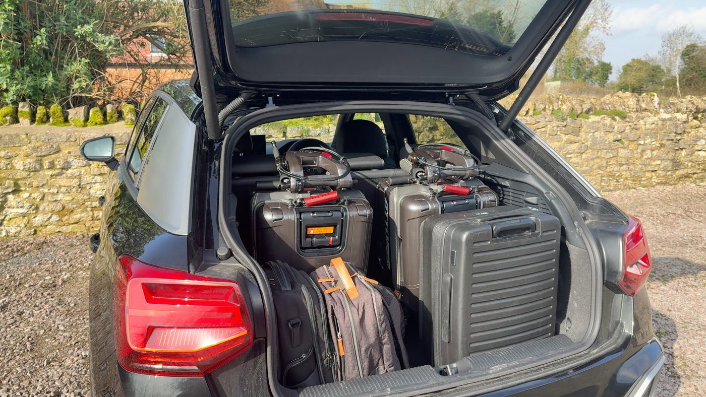 Two ATTO folding mobility scooters side by side in the boot of an Audi Q2 SUV