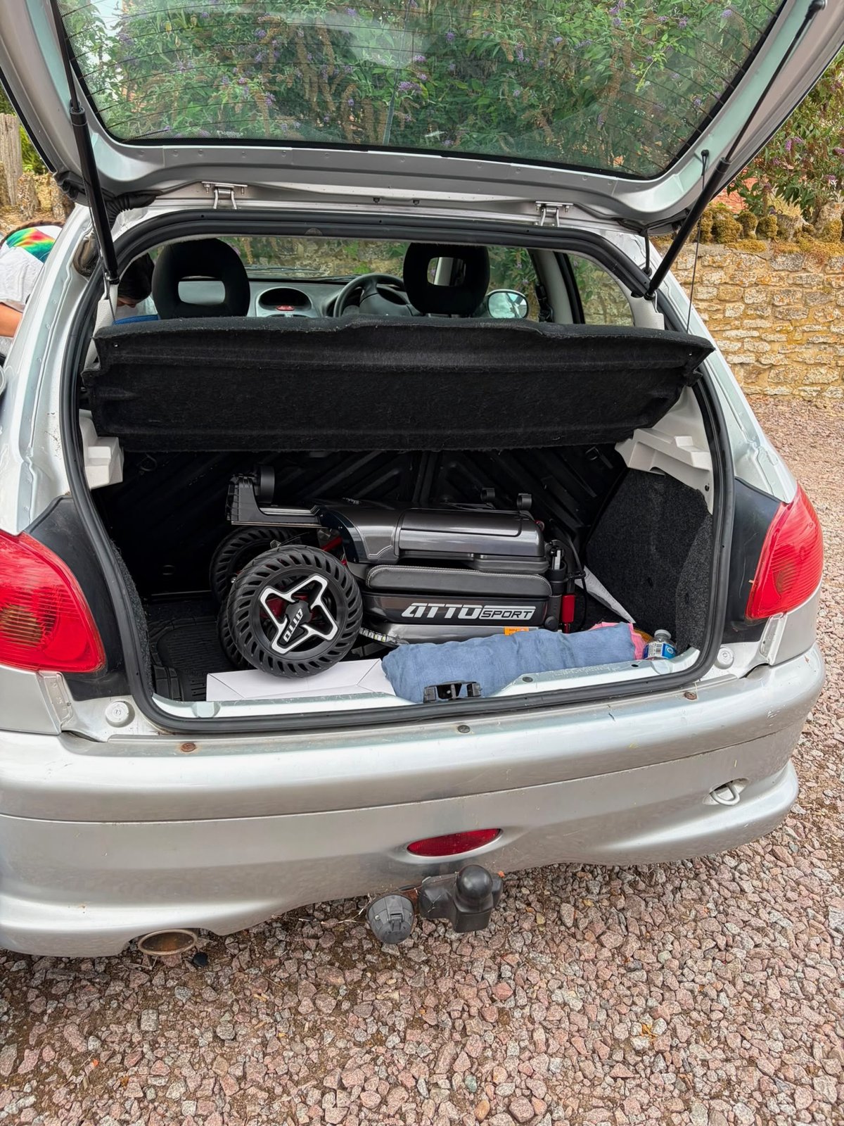 Folded ATTO Sport folding mobility scooter loaded in the boot of a Peugeot 208